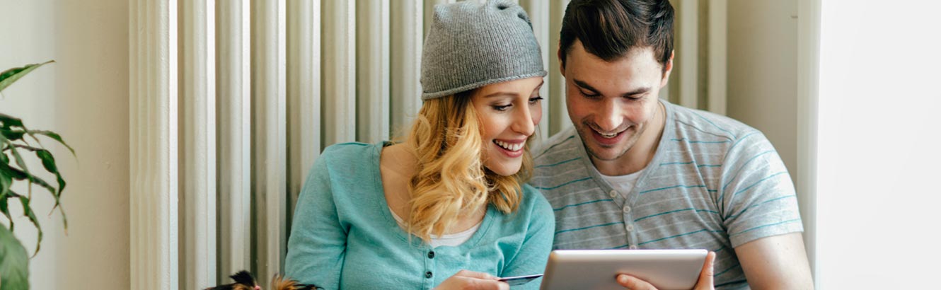 Young couple using tablet in living room