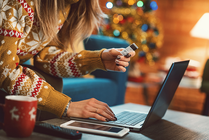 Woman with credit card at laptop.